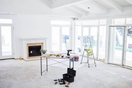 Shot of building plans and equipment on a table in an empty living room during the day